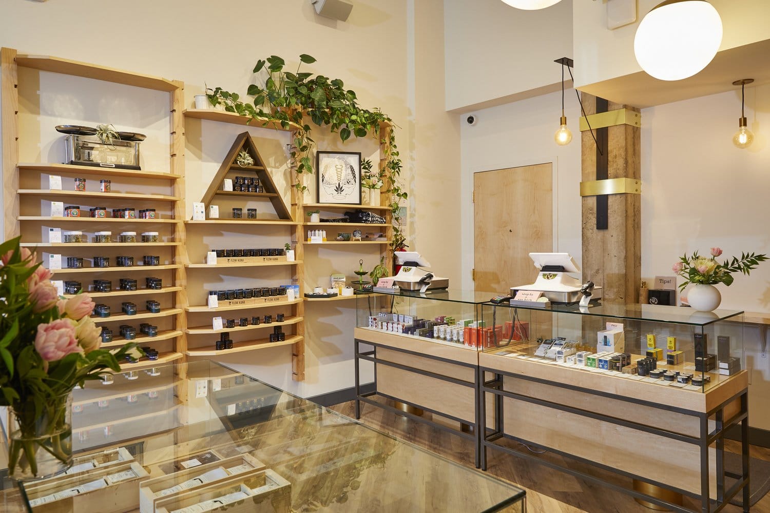 A well-organized retail cannabis dispensary with glass display cases and wooden shelves filled with cannabis products.